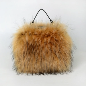 Brown faux raccoon fur handbag with black strap and gold metal hardware on white background