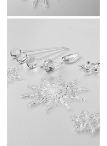 Macro detail of clear acrylic snowflake and crystal waterdrop Christmas tree ornaments