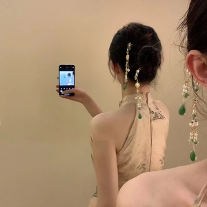 Détail d'un pic à cheveux chinois vintage avec perles vertes et longs glands