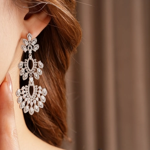 Gros plan détaillé de boucles d'oreilles fleurs vintage avec zircons sur un mannequin