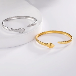 Detail of adjustable snake head bracelets in polished gold and silver finishes