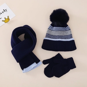Détail de l'ensemble bonnet rayé, écharpe et moufles avec texture douce et pompon