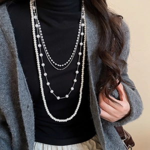 Detail of layered French vintage pearl necklace with crystal beads on a model sweater