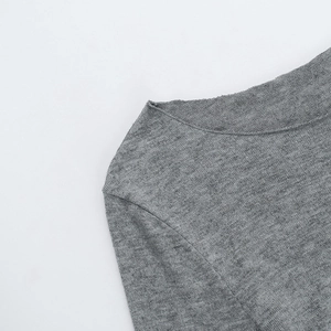 Detail view of the gray knit top showing the ribbed neckline and shoulder texture clearly