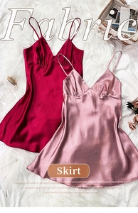 Detail of red and pink satin slip dresses with V-neck and thin straps on plush rug