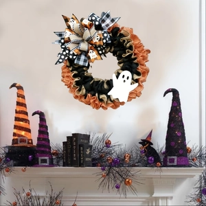 Halloween wreath with black and orange burlap mesh and white ghost silhouette over a mantel