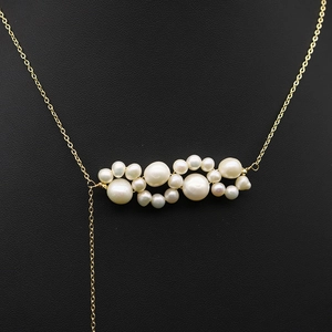 Vintage gold Y-necklace with natural pearls and elk pendant on black background