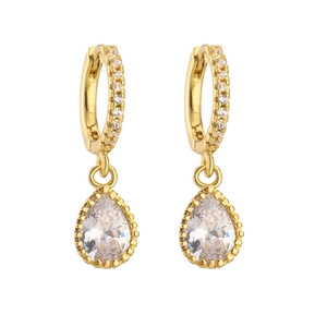 Macro shot of gold-plated huggie earrings with sparkling pear-cut zircon pendants