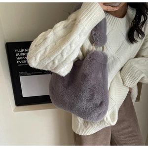 Gros plan sur un sac à main en peluche gris-violet avec une poignée ronde chic