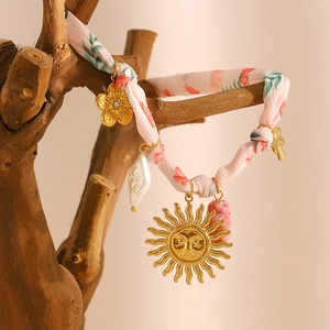 18K gold-plated ribbon necklace with sun face pendant and baroque pearl on wood branch
