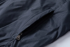 Detail of zip pocket on men's lightweight ripstop jacket showing grid texture
