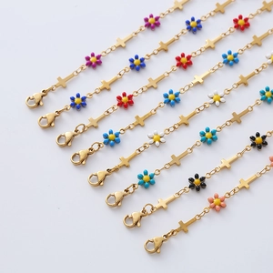 Macro shot of 18k gold plated stainless steel bracelets with colorful enamel daisies