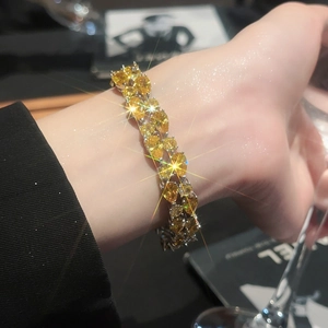 Macro detail of pear-cut yellow zircon bracelet with silver setting on a wrist