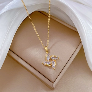 Golden spinning flower necklace with crystal zircon in a brown luxury jewelry box