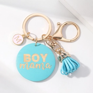Golden keychain with blue BOYMAMA wooden charm, pink M pendant and a blue fringe tassel