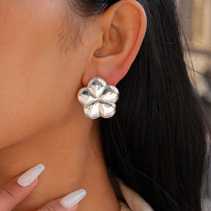 Chic silver metallic flower stud earrings with a high-polished finish on model