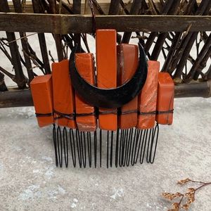 Macro detail of natural red stone hair comb with a black moon accent for bride styling