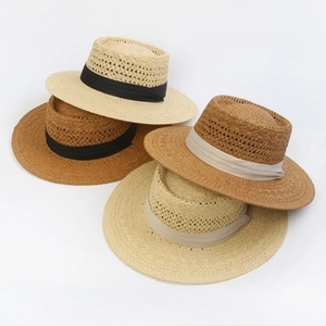 Flat top straw hats with镂空 weave and decorative ribbons in beige and caramel colors