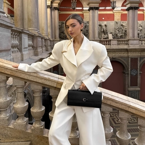 Elegant white oversized blazer suit with wide-leg trousers in a classic indoor setting