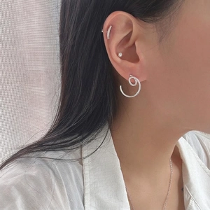 Minimalist 925 sterling silver earring set with spiral hoops and studs on model ear
