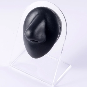 Macro side view of a black silicone nose model on a clear acrylic display stand