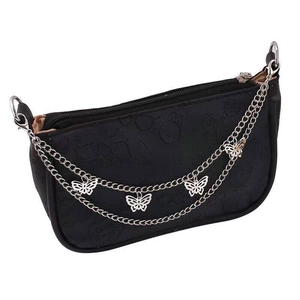 Detail einer Silberkette mit Schmetterlingsanhängern an einer schwarzen PU-Handtasche