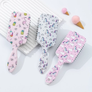 Detailed view of three cartoon unicorn hair brushes with massage air cushion design