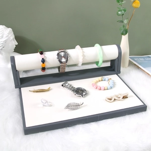 Gray and white jewelry display stand with crossbar for watches and bracelets on faux fur