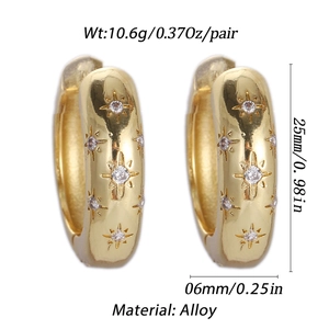 Macro view of gold-plated hoop earrings with star engravings and zircon detailing