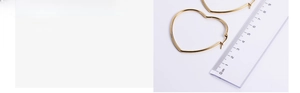 Detailed view of large vacuum gold-plated heart hoop earrings with a size reference scale