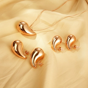 Polished rose gold waterdrop necklace and earrings jewelry set on champagne silk fabric
