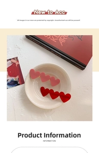 Detail of red and pink acrylic heart hair clips displayed in a ceramic bowl
