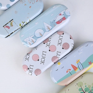 Macro shot of rectangular metal tin cases featuring diverse colorful cartoon illustrations
