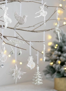 Detail of silver glitter ballet dancer and star ornaments on a festive Christmas tree