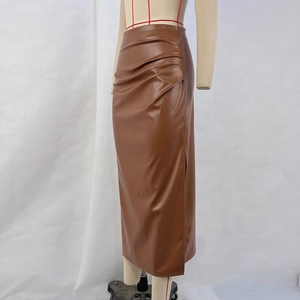 Detail view of brown PU leather skirt featuring waist pleats and side slit texture