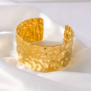 Minimalist wide open cuff bracelet with 18K gold plated hammered texture on white silk