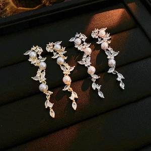 Detailansicht der gold- und silberfarbenen Perlenohrringe mit Zirkonia-Ähren-Design