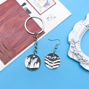 Detailed view of black enamel mountain and moon charms for DIY earrings and keychains