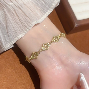 Detailed view of elegant gold cutout chain bracelet worn on wrist for a luxury fashion look