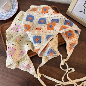 Detailed close-up of handmade crochet floral bandana on wooden tray with cozy vibe