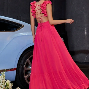 Détail d'une robe en mousseline fuchsia avec bretelles croisées et ourlet à volants