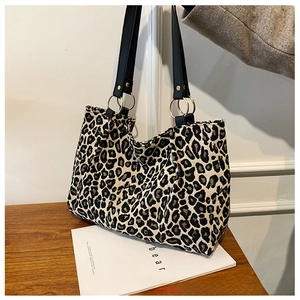 Detailed view of leopard print canvas tote bag with gold rings and black straps