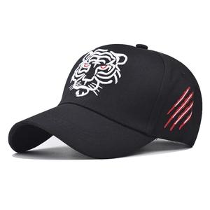 Detail of tiger head embroidery and red scratch marks on black cotton baseball cap