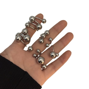 Polished stainless steel spiral ring with dual metal spheres shown on hand