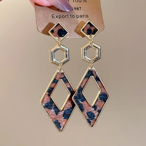 Detail view of leopard print leather earrings with gold geometric layered design