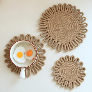 Detailed top view of three round woven hemp placemats in natural khaki fiber