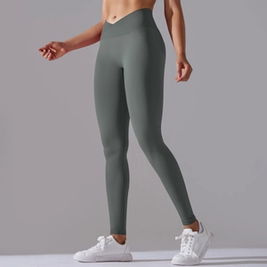Detail showing high-waisted crossover design of seamless green yoga leggings for women
