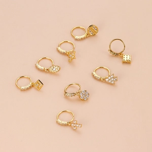 Set of seven gold-plated nose rings with cross, star, and eye pendants featuring zircons