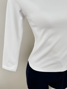 Detail view of the white slim fit top showing the fine cotton fabric and waist hemline
