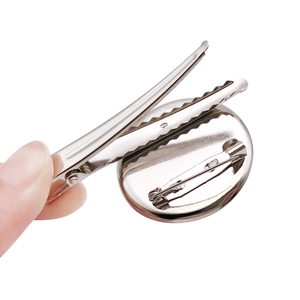 Close-up of silver metal brooch base with clip and pin back accessories for jewelry
